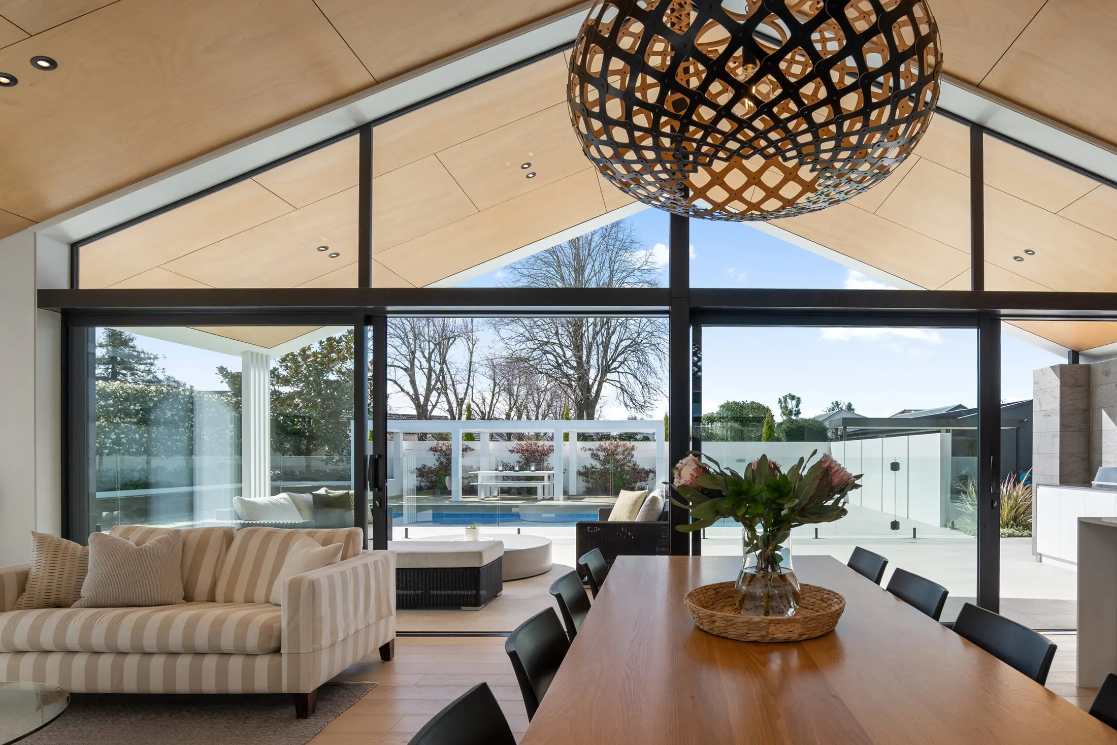 Gabled living room with timber ceiling and garden views